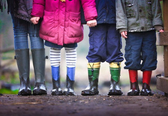 four children standing on dirt during daytime