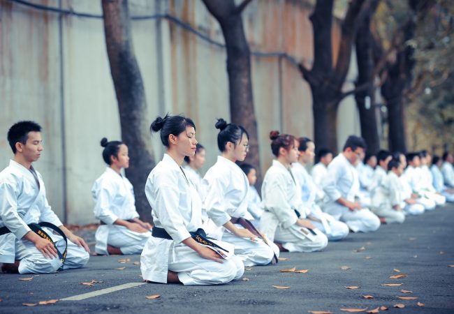 group of martial artists sitting on the grounds