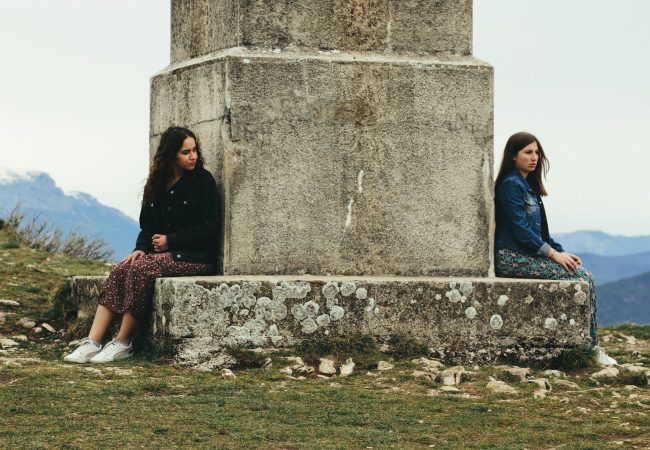 woman in black jacket sitting beside woman in black jacket