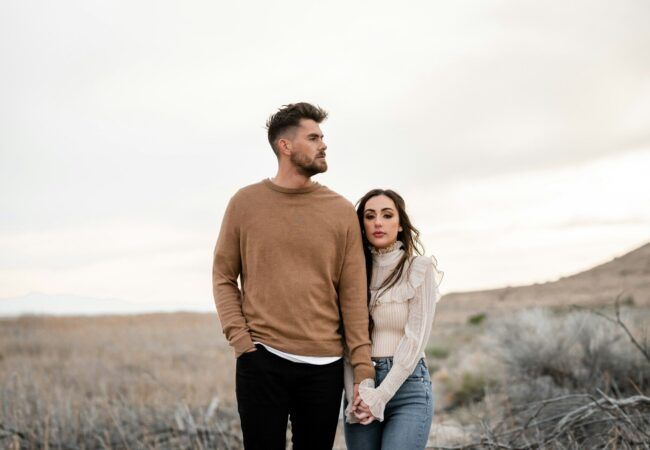 A man and a woman standing in a field